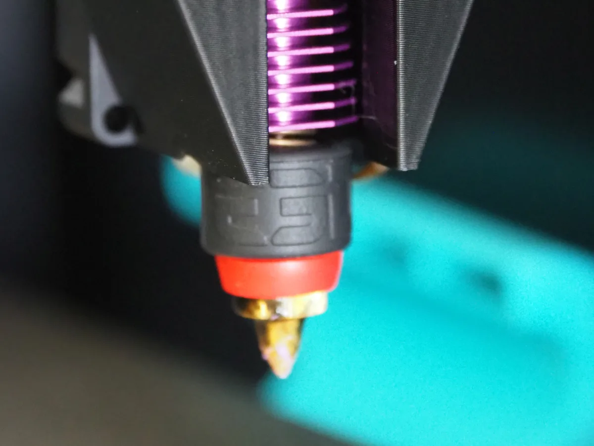 Close-up of the extended brass nozzle under the Melta MK1 toolhead